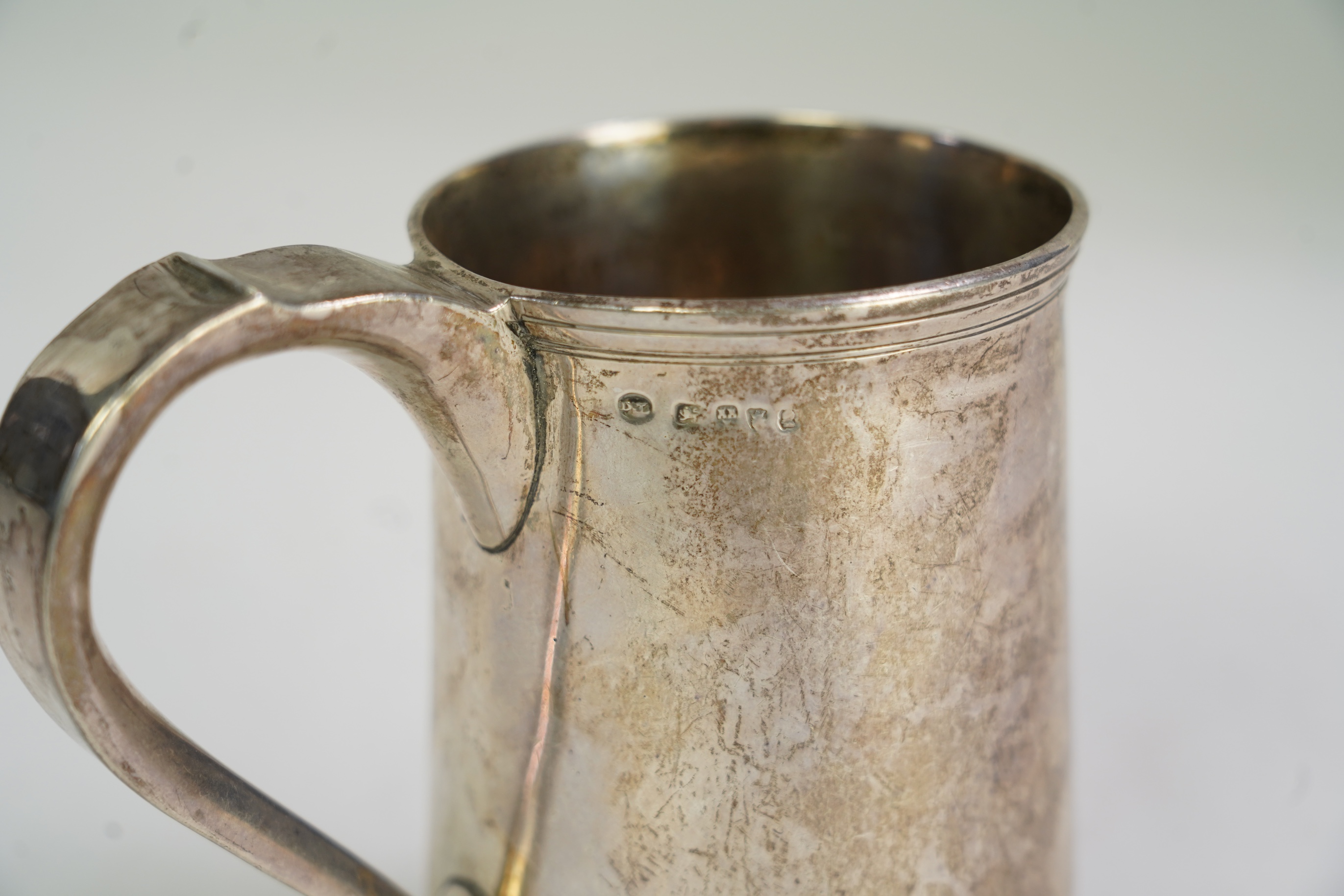A George III provincial silver mug, by Dorothy Langlands, of plain design, with scroll handle, no date latter, Newcastle, circa 1810, height 13.1cm, 10.6oz, (a.f.).